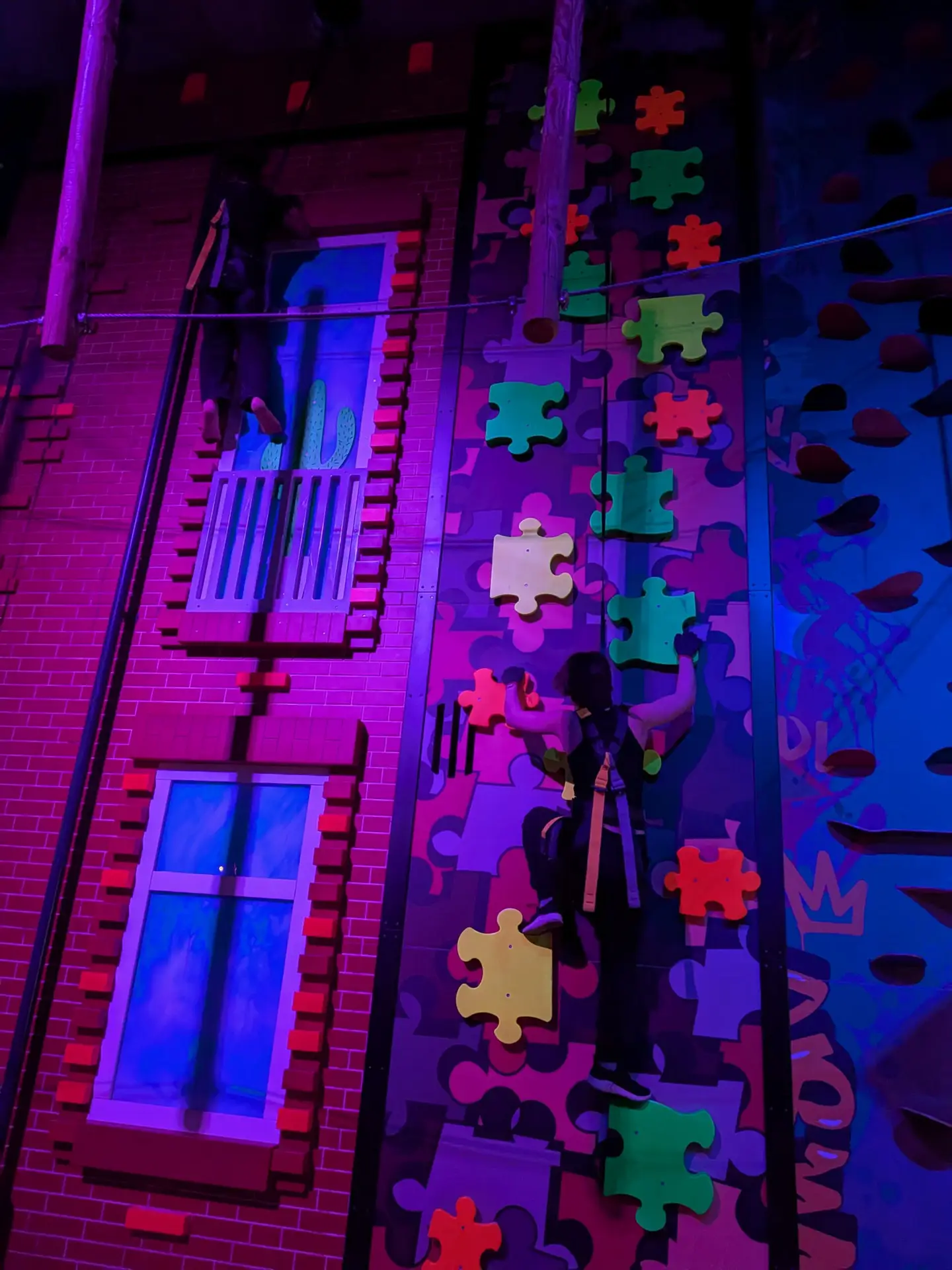 Klettern an einer beleuchteten Wand mit Puzzlegriffen.